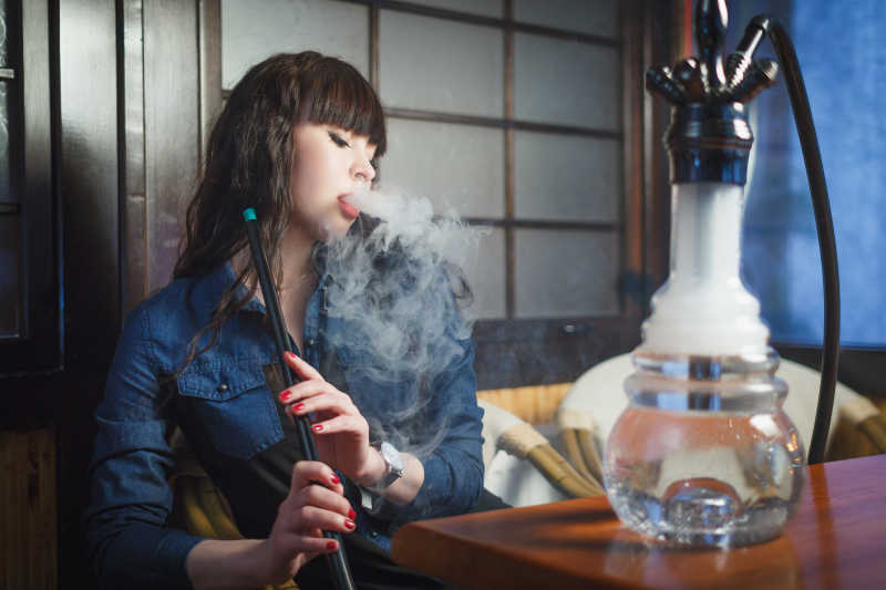 酒吧里抽水烟的年轻女人