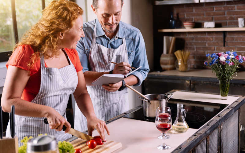 聪明漂亮的女人一边切菜一边向男人吐露配料