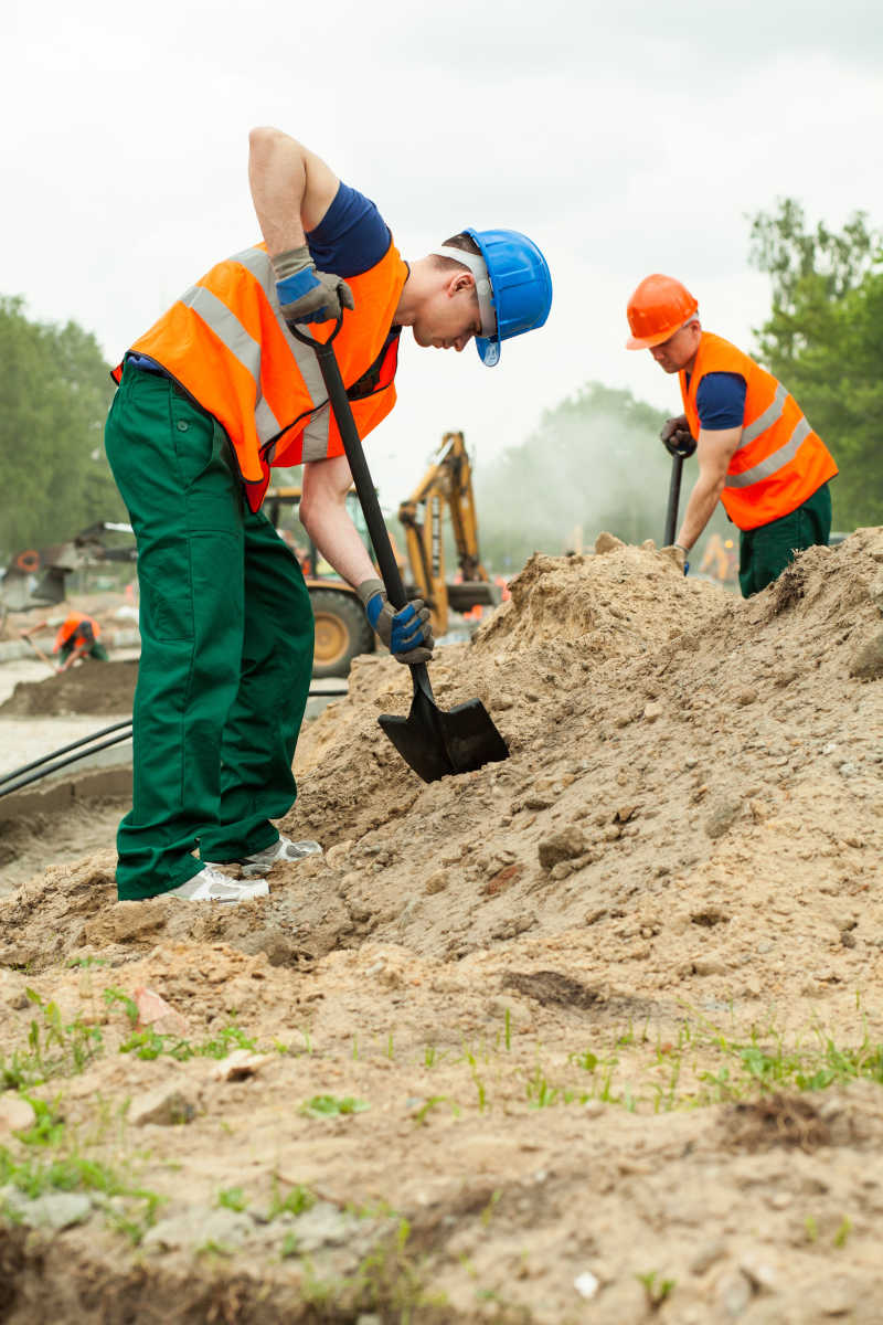 建筑工人用铲子挖土