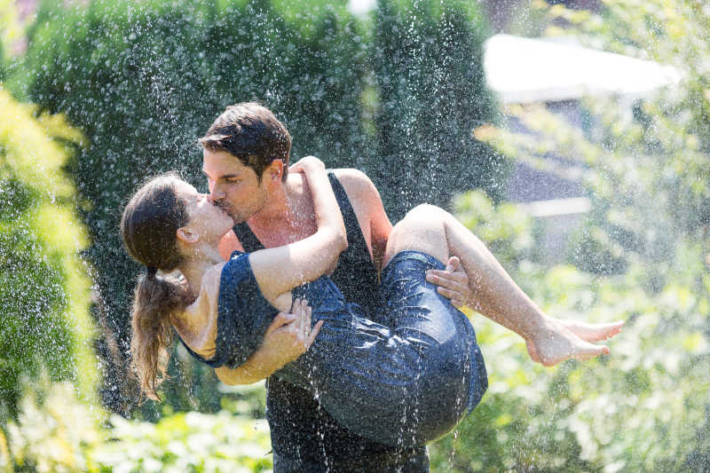 在水中浪漫亲吻的年轻夫妇