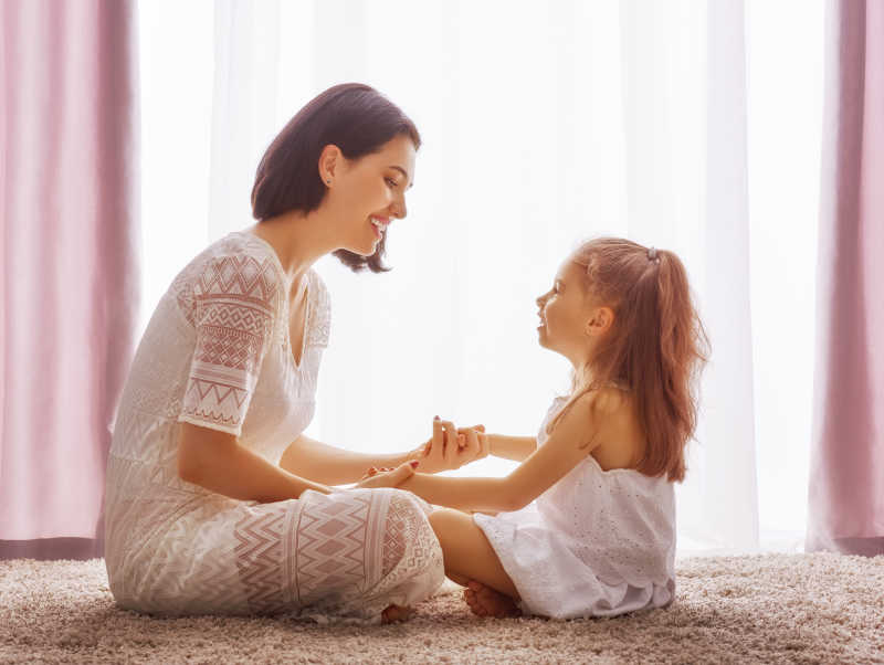 窗前母亲陪伴女儿一起玩耍