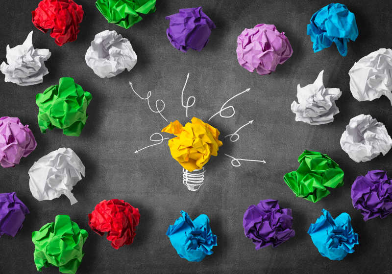 五颜六色的纸褶球和一个黄色的纸褶灯泡