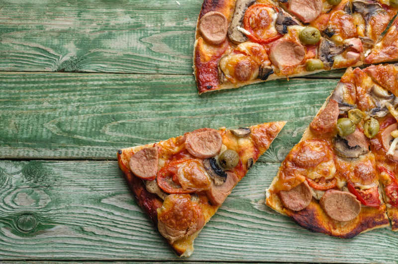 木桌上新鲜美味的切成三角形的披萨饼