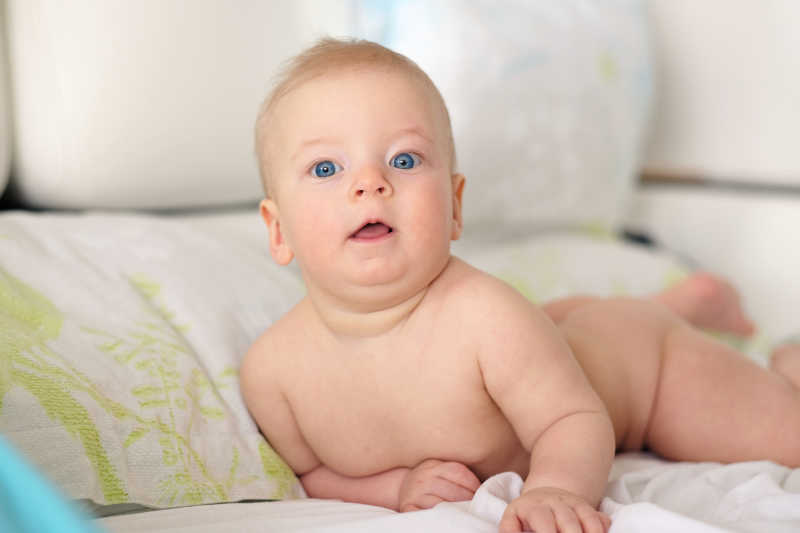 可爱的床上趴着的蓝眼睛的宝宝