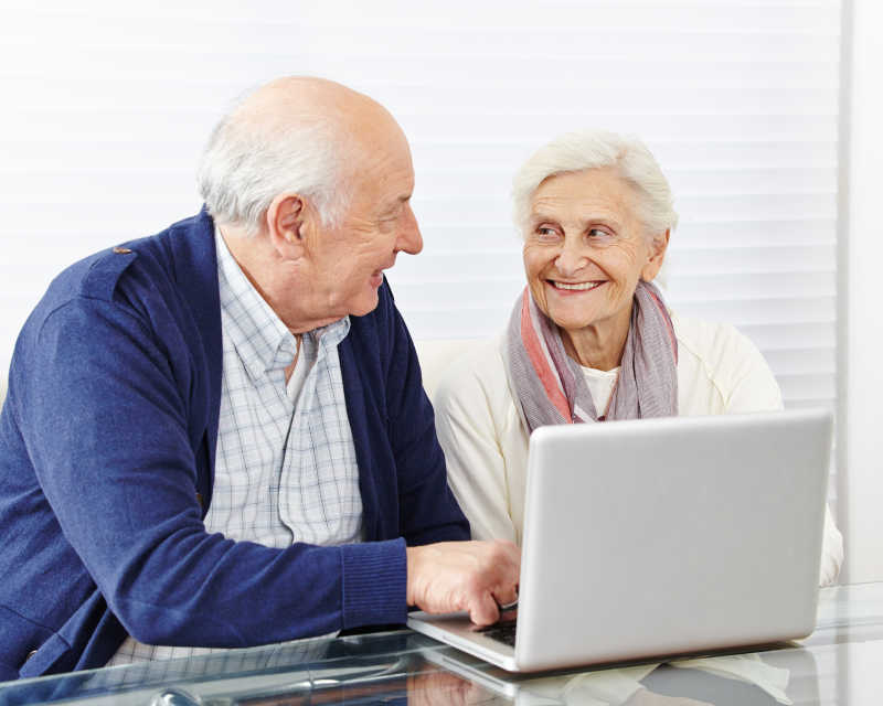 两个一起用电脑的幸福的老人