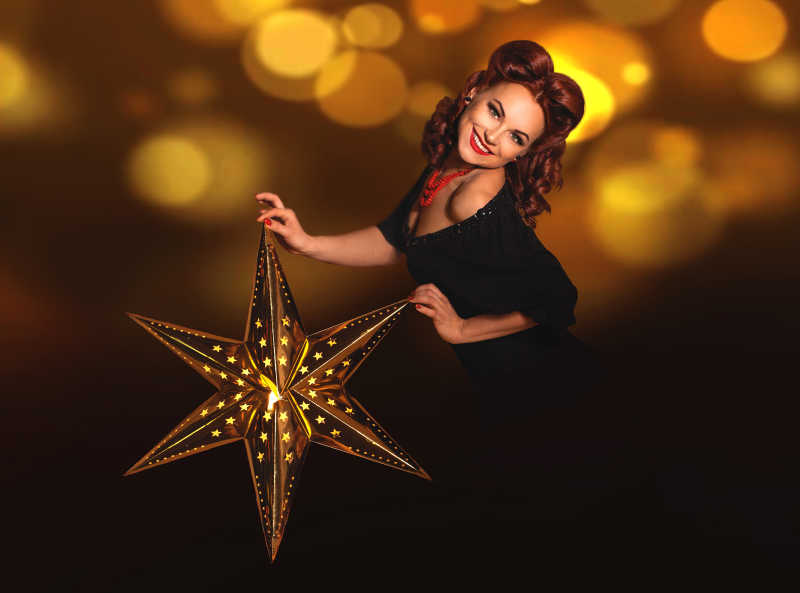 年轻漂亮的拿着星形灯的复古年轻女性