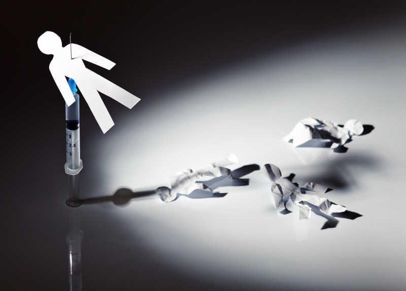 三个有皱褶的纸人和扎在注射器上的纸人