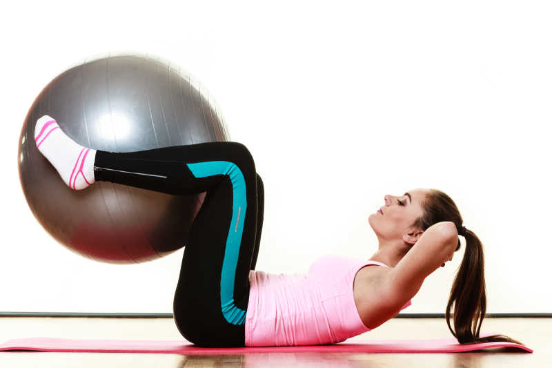 年轻的快乐女子做健身操配球