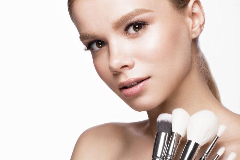 手拿化妆刷的微笑美女