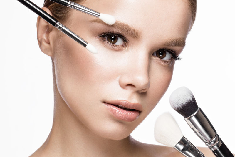 用化妆刷修饰眉毛的美女