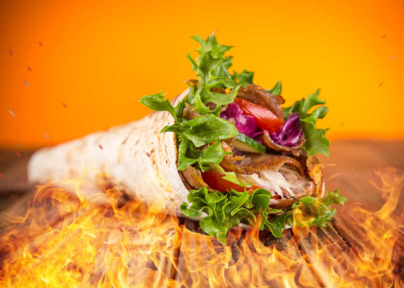 大火背景下的美味的烤肉卷饼