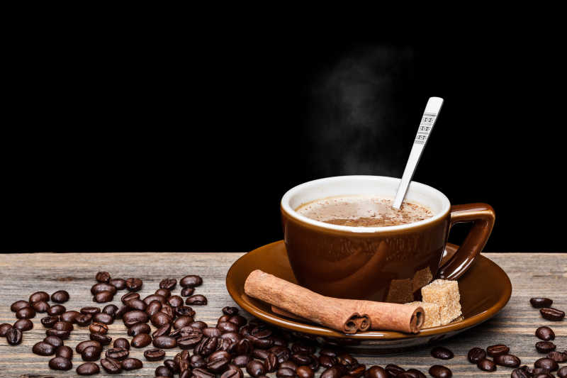 木桌上散落的咖啡豆和一杯美味的咖啡