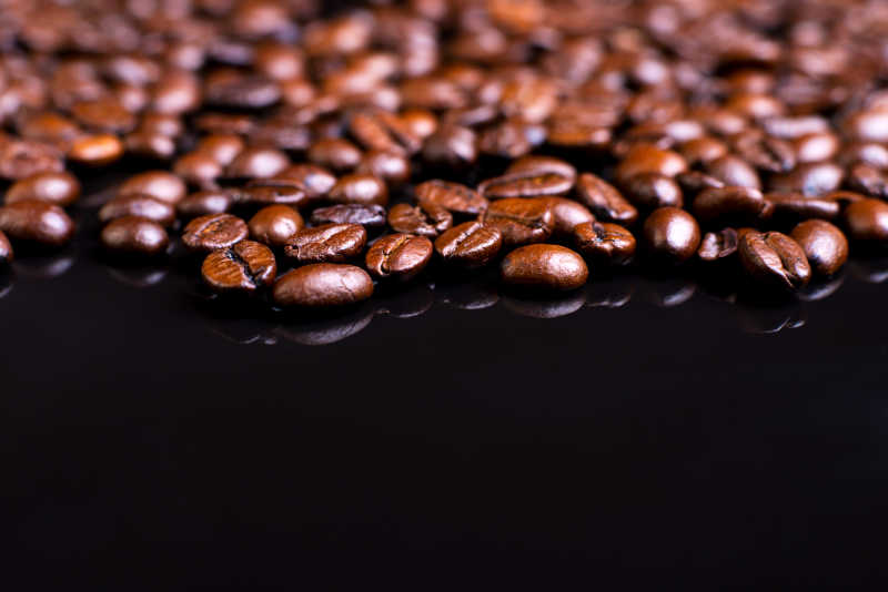 黑色玻璃桌上面的咖啡豆