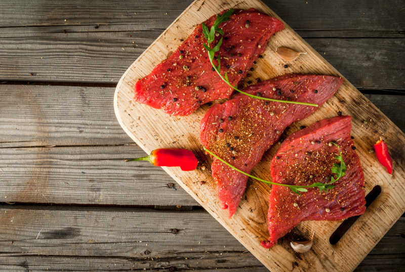 木板上木托盘里调好的红色生肉