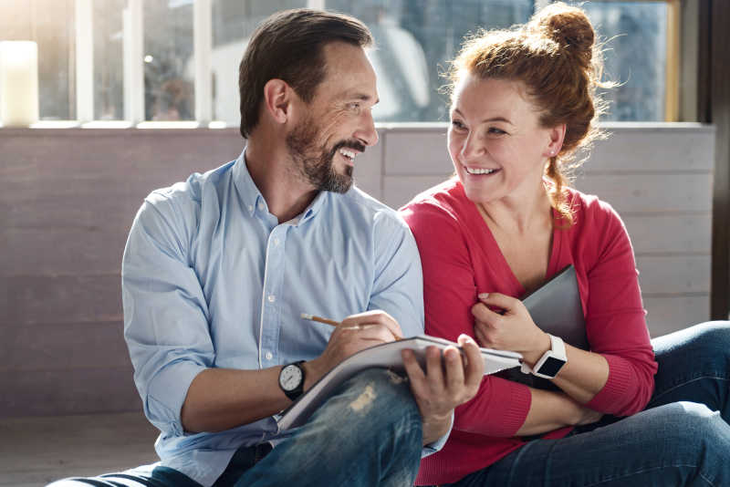 地板上有笔记和药片的中年夫妇