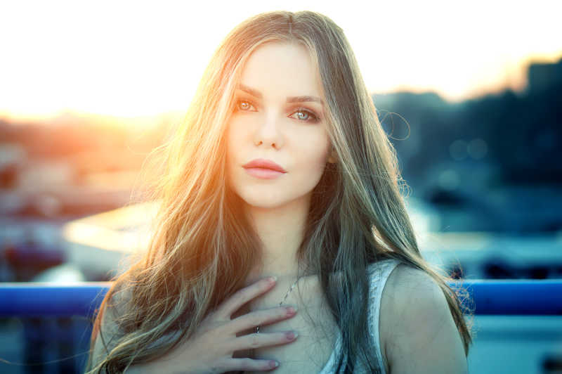 在美丽的夕阳尽头的屋顶上年轻女孩