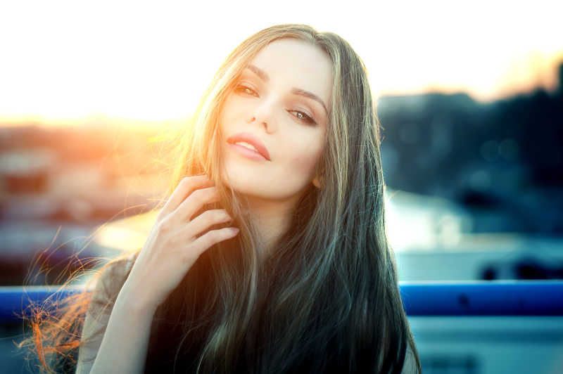 夕阳下屋顶上的性感长发美女