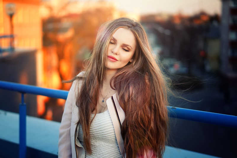 夕阳下屋顶上的长发美女