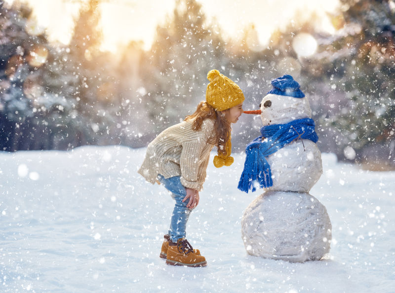 可爱的小女孩伸手去抓雪花