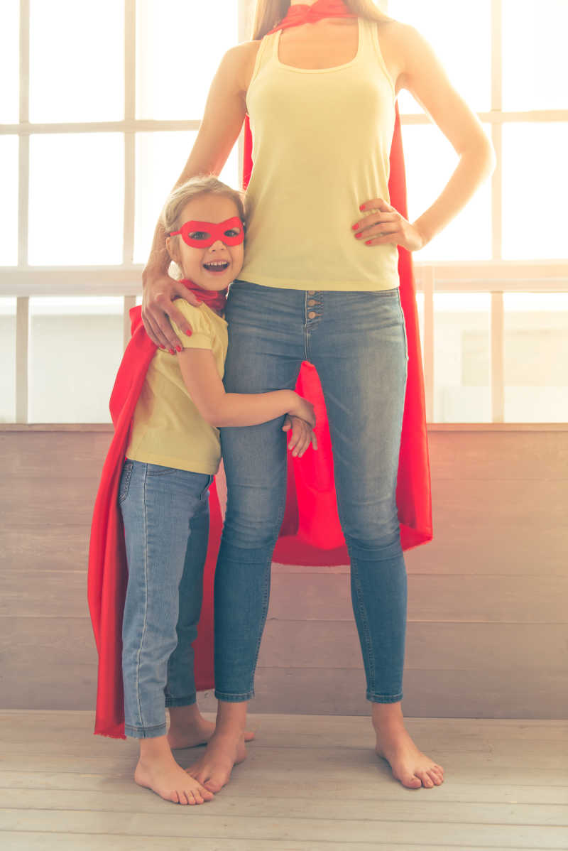 站在窗户前打扮成超级英雄的母女