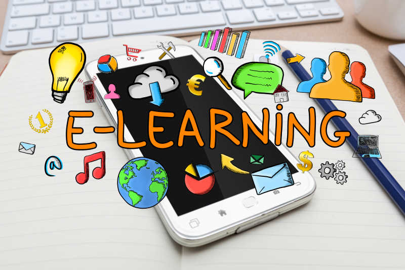 纸质笔记本上的智能手机和彩色手绘E-learning图标
