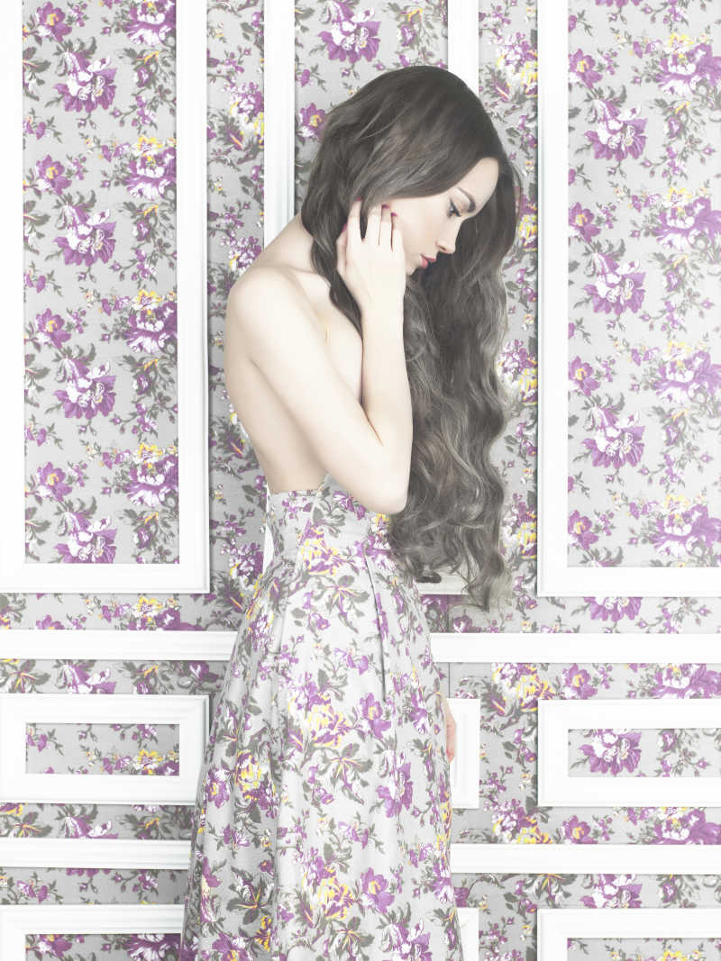 花卉图案墙壁前的性感女孩