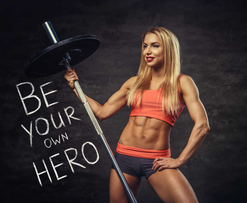 性感的金发女子拿着杠铃健身