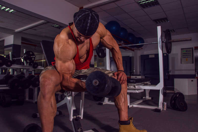 健身房里的健身锻炼二头肌的男人