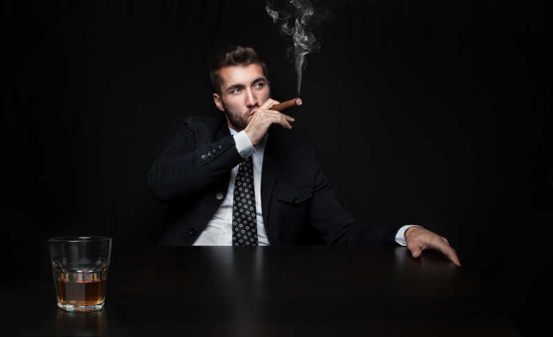 黑色背景下吸烟的商人