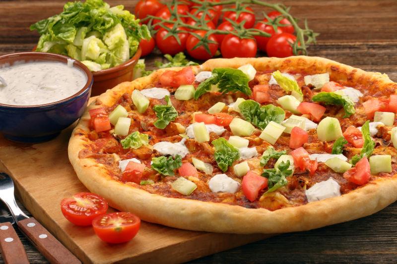 木制背景下美味的自制鸡肉和蒜酱比萨饼