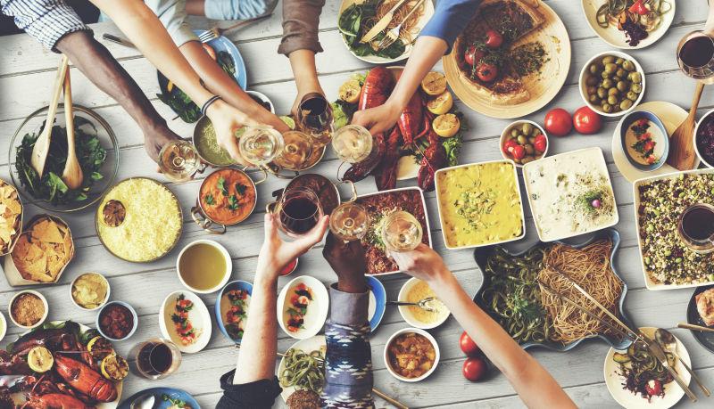 美食桌上聚餐举杯的美女