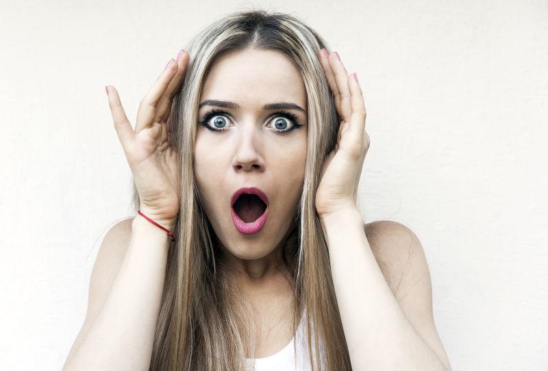 白色背景下长着嘴惊讶的年轻女孩