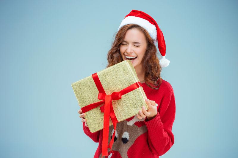 美女穿着圣诞帽的带着圣诞礼物