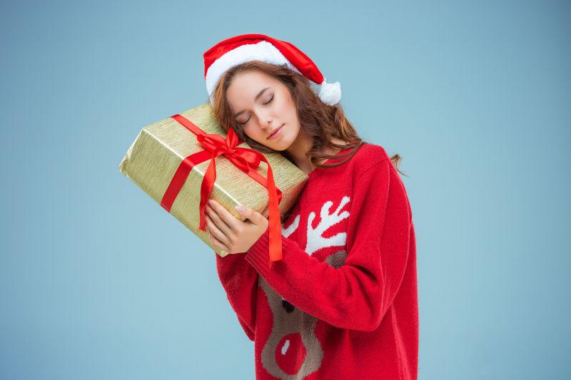 穿着圣诞帽的美女带着圣诞礼物