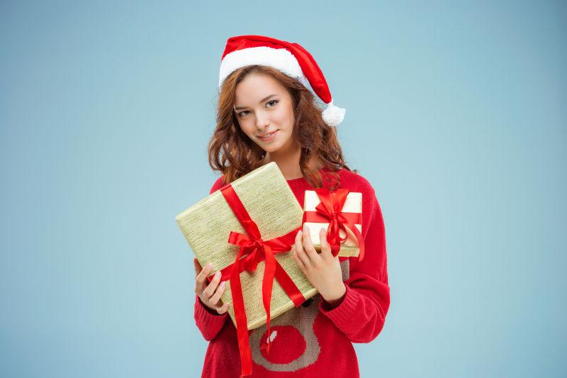 女孩带着圣诞帽拿着圣诞礼物