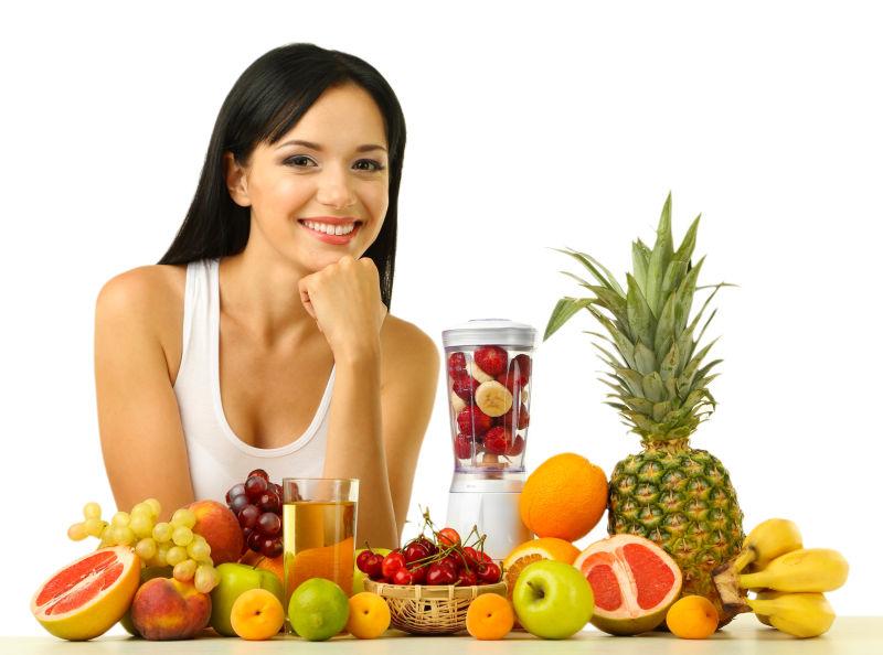 微笑的年轻美女和各种新鲜水果果汁