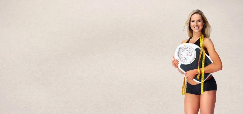 健身美女拿着皮尺