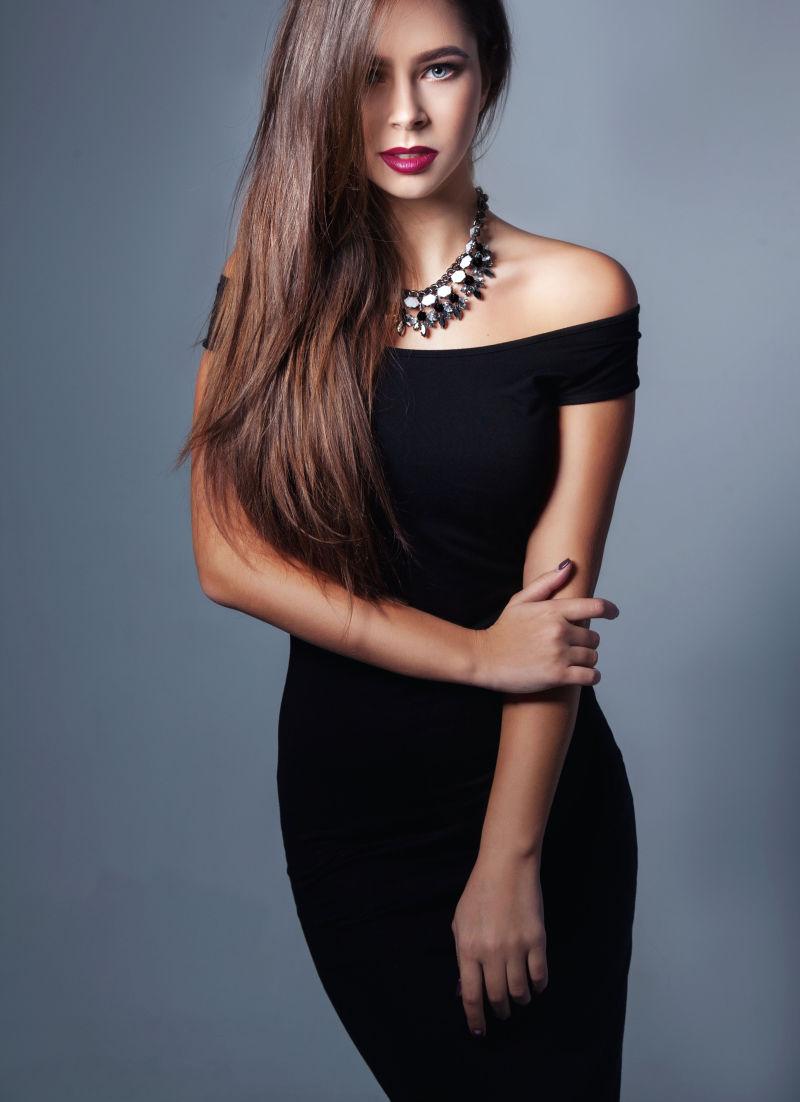 时尚黑色连衣裙的长发美女