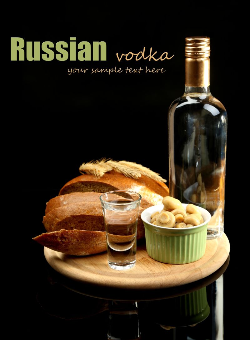 黑色背景下木桌上的一瓶伏特加与腌制蘑菇新鲜面包