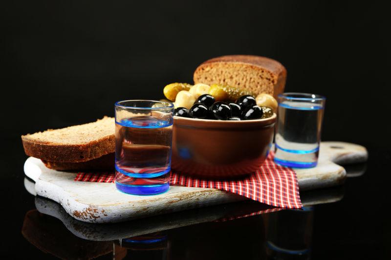 黑色背景下用伏特加酒和浸泡过的蔬菜做成的混合物