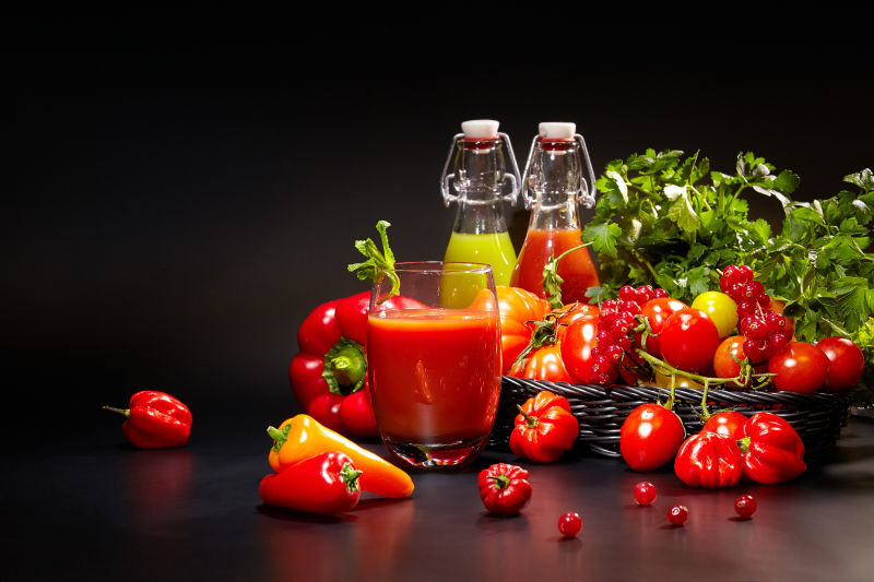 黑色背景下的有机蔬菜和蔬菜汁