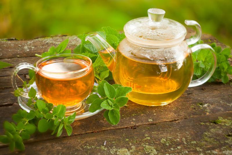 放在木桌上盛满绿茶的茶具