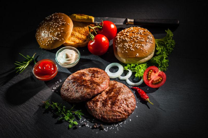 黑背景中烤牛肉馅饼和自制汉堡包配料