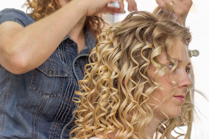 理发师在给金发美女卷发