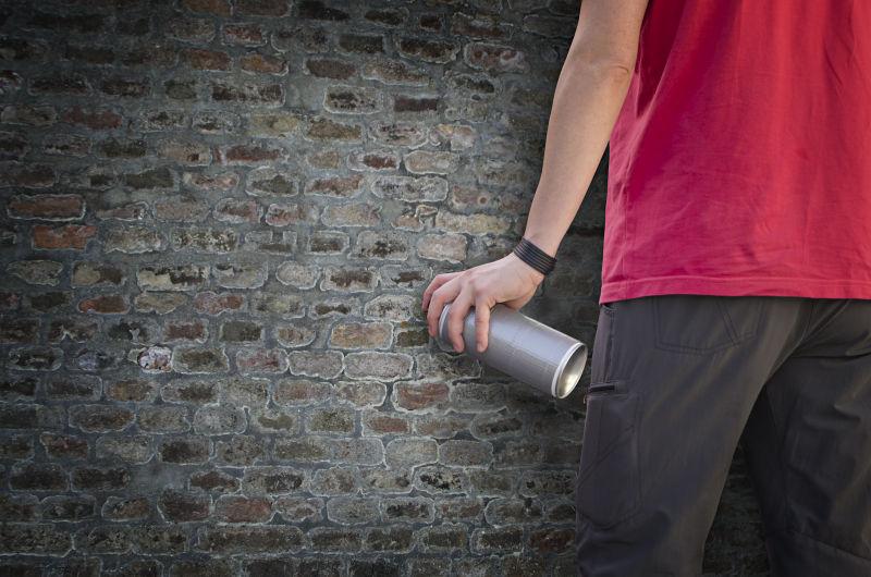 手拿着涂鸦喷雾的人