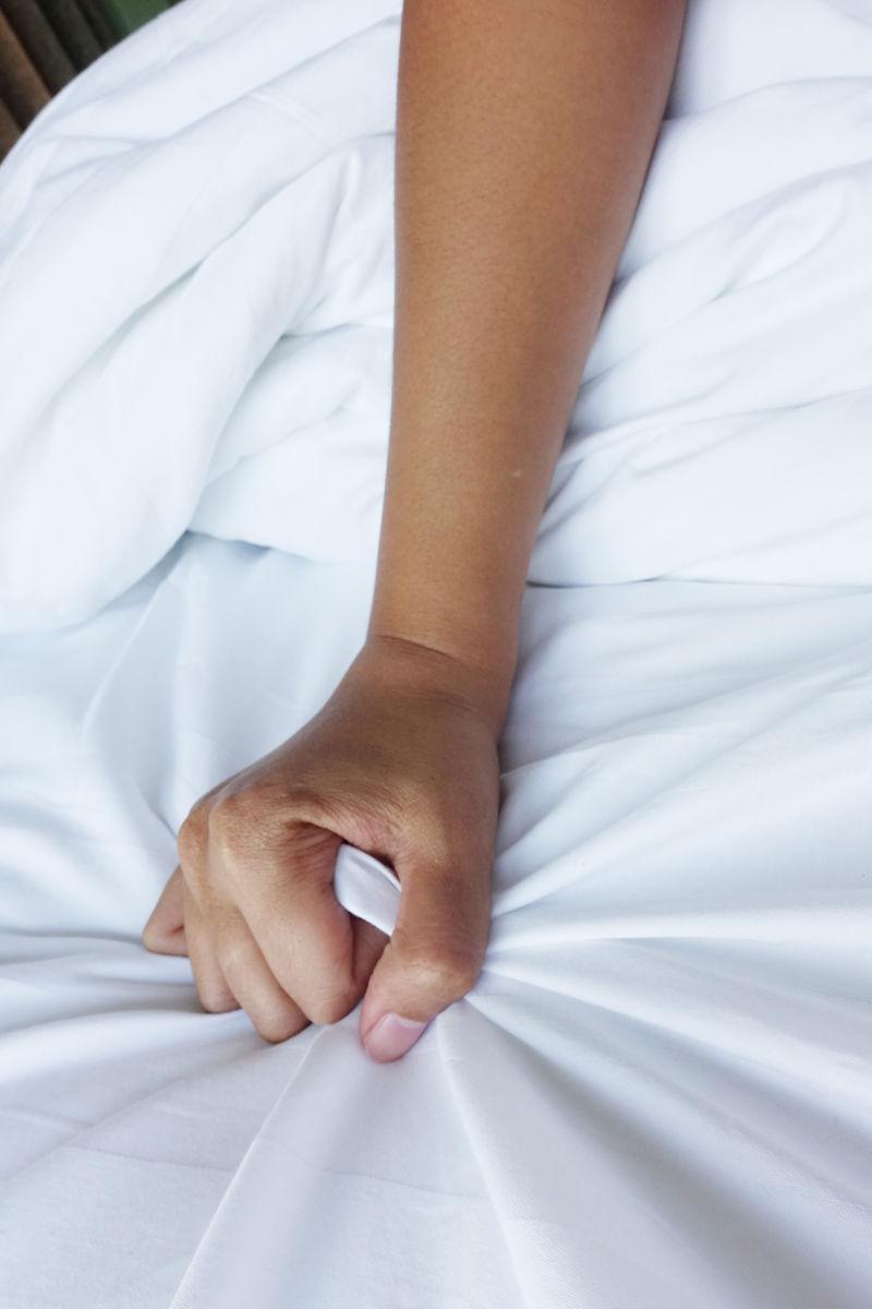 女人的手拉着白色床单
