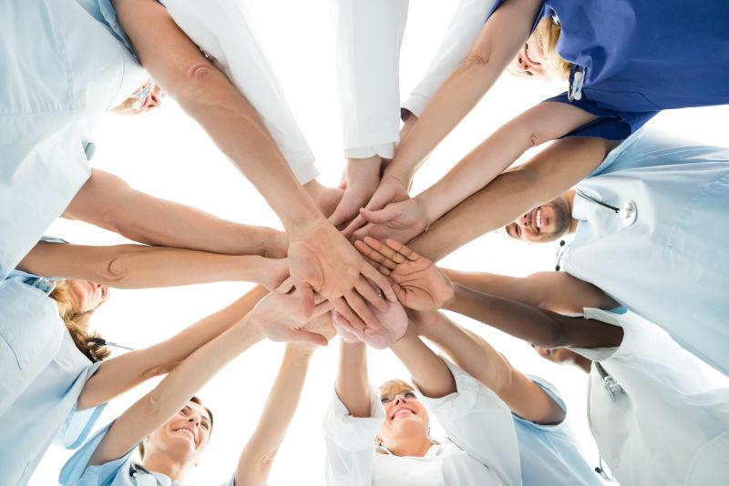 一个团队开心的将手交叠在一起