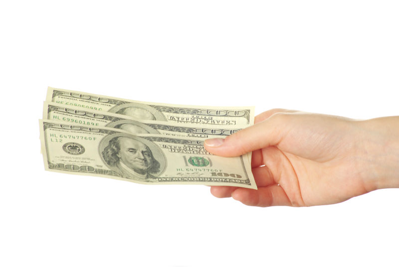 拿着三张美元钞票的手