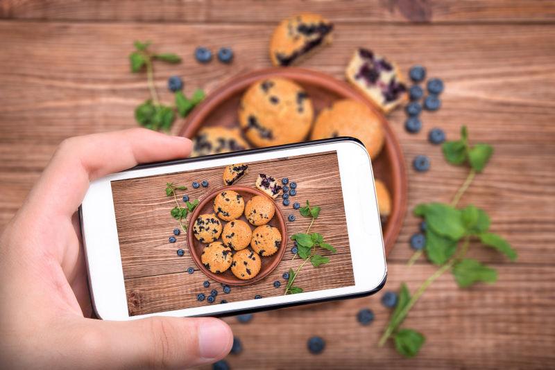 手拍照蓝莓松饼与智能手机