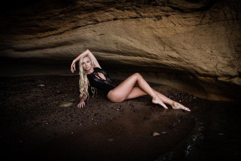 性感的金色长发美女躺在沙滩上